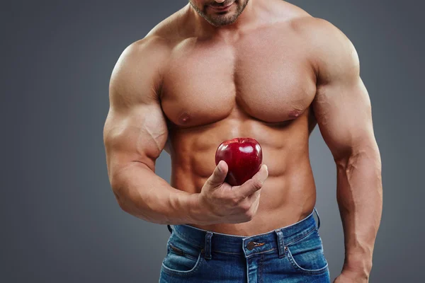 Muscle fort homme tenant une pomme rouge — Photo