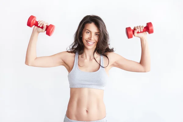 Smiling athletic woman pumping up — Stock Photo, Image