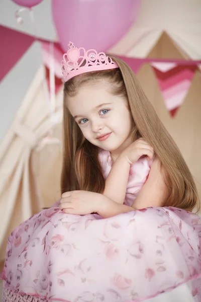 Милая улыбающаяся маленькая девочка в розовой принцессе — стоковое фото