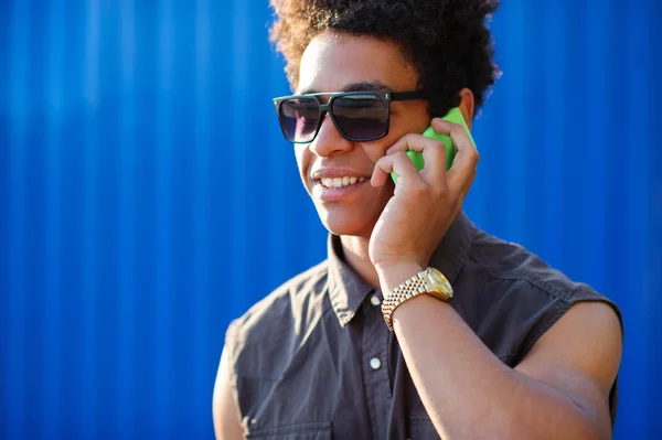 Молодой улыбающийся мужчина с помощью смартфона — стоковое фото