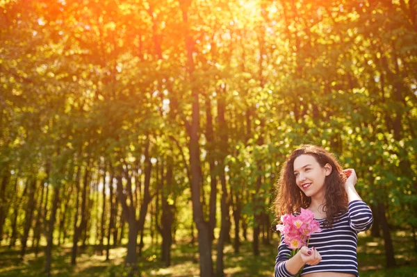 Красива дівчина з квітами на відкритому повітрі — стокове фото