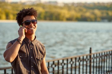 Genç adam cep telefonuyla konuşuyor.