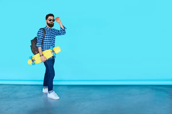 Joven hipster hombre con un monopatín —  Fotos de Stock