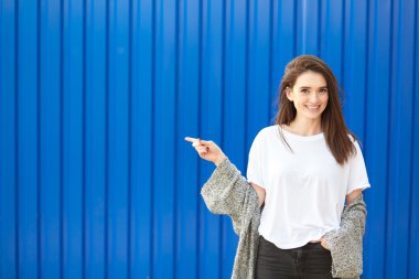 Hipster girl posing against blue background clipart