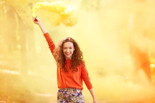 Jeune femme avec nuage de poudre coloré — Photo