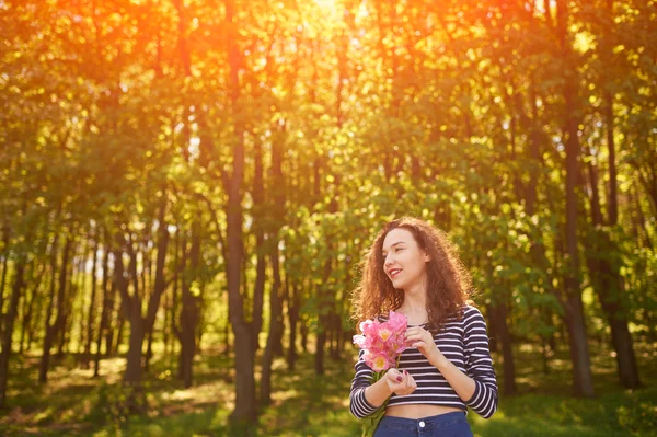 Schönes Mädchen mit Blumen im Freien — Stockfoto