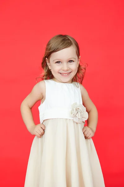 Cute little girl in white dress smiling on camera — Stock Photo, Image