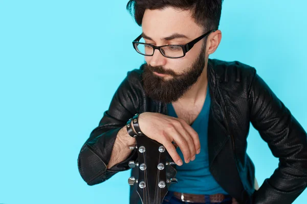 Jeune garçon posant avec guitare contre mur bleu — Photo