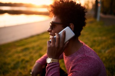 Genç adam telefonda konuşuyor.