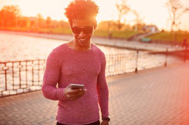 Genç adam akıllı telefon kullanıyor.