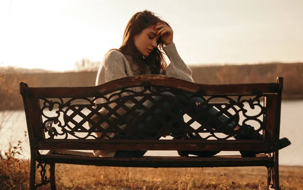Jeune femme frustrée assise sur un banc dans un parc — Photo