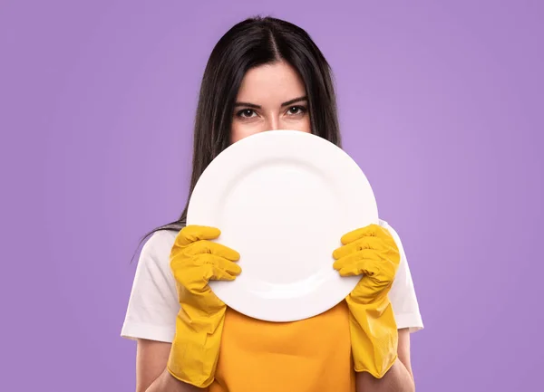 Hausfrau zeigt sauberen weißen Teller — Stockfoto