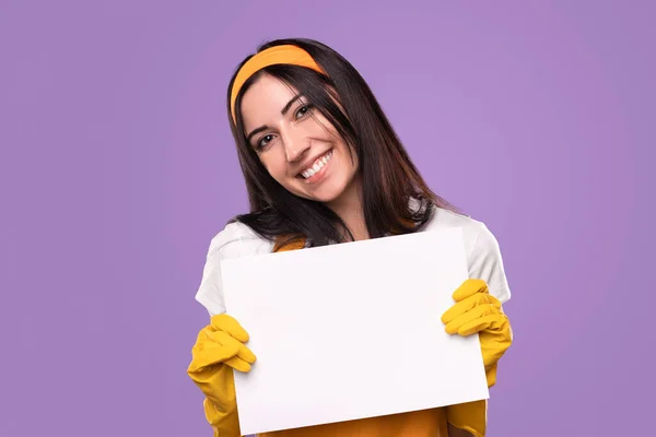 Fröhliche Hausfrau zeigt weißes Papierblatt — Stockfoto