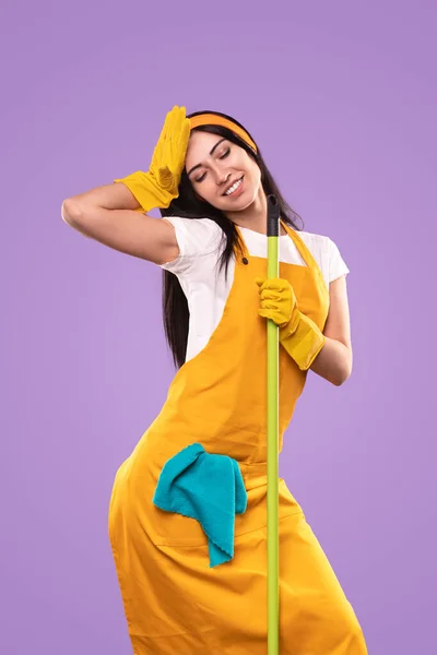 Donna sorridente che riposa durante i lavori domestici — Foto Stock