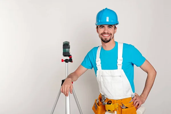 Happy builder leaning on digital level — Stock Photo, Image