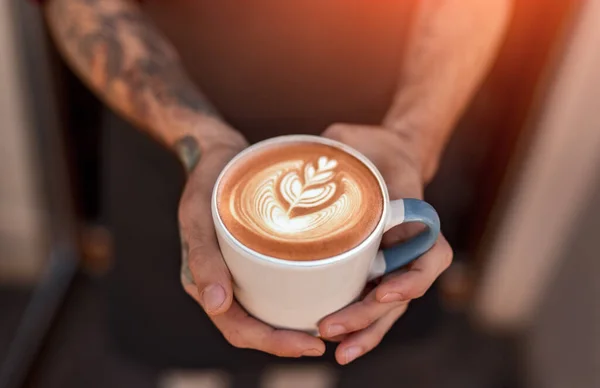 Barista sosteniendo una taza de café con latte art — Foto de Stock