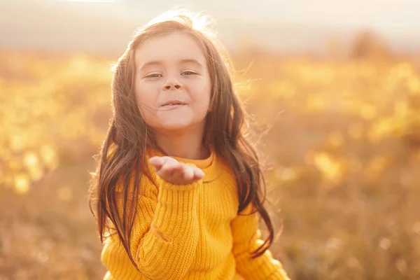 Uśmiechnięta dziewczynka wysyła pocałunek powietrza w polu — Zdjęcie stockowe