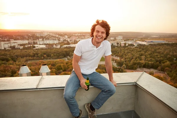 Chico alegre con cerveza en la azotea —  Fotos de Stock