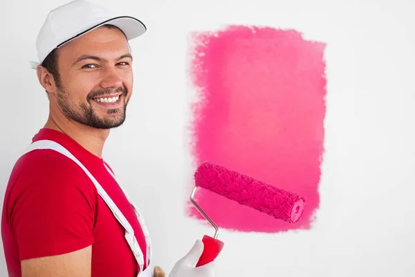 Pintor alegre con rodillo mirando a la cámara — Foto de Stock