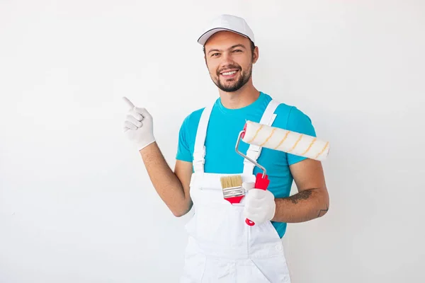Smiling painter with roller and brush — Stock Photo, Image