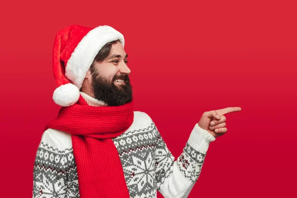 Homem alegre em roupas de Natal apontando para o lado — Fotografia de Stock