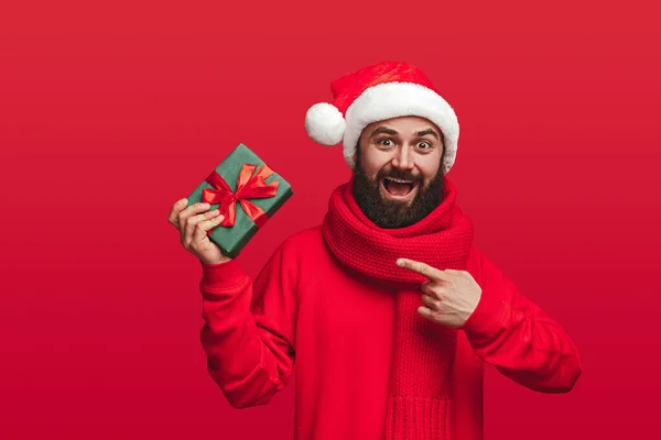 Homem barbudo incrível demonstrando caixa de presente de Natal — Fotografia de Stock