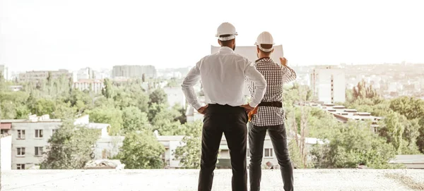 Arquitectos discutiendo plan de construcción en ciudad —  Fotos de Stock