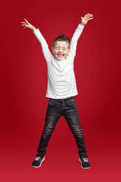 Захоплений маленький хлопчик у повсякденному вбранні святкує успіх — стокове фото