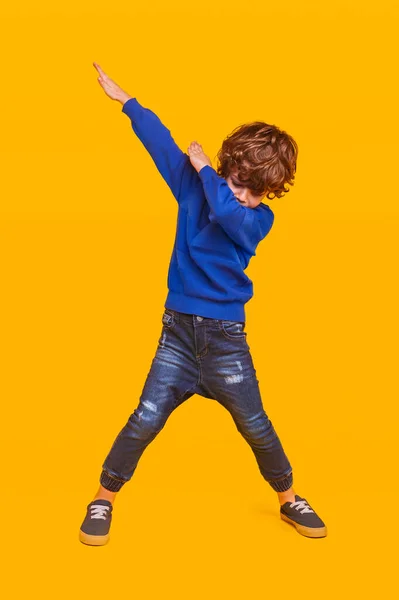 Енергійний хлопчик танцює на жовтому тлі — стокове фото