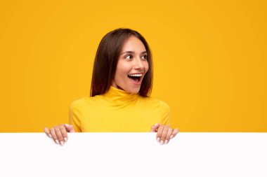 Boş beyaz posterli heyecanlı bir kadın.