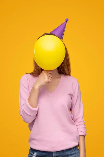 Mulher anônima cobrindo rosto com balão de aniversário — Fotografia de Stock