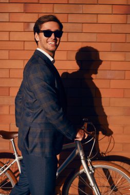 Şehirde bisikleti olan neşeli moda işadamı.