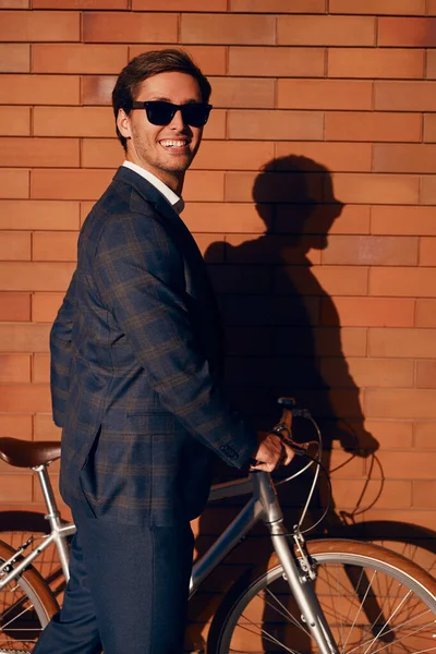 Alegre empresario de moda con bicicleta en la ciudad —  Fotos de Stock