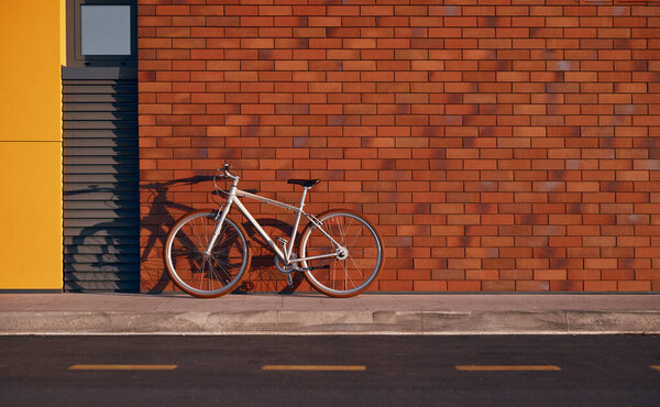 Stylish urban bicycle on sidewalk with brick wall