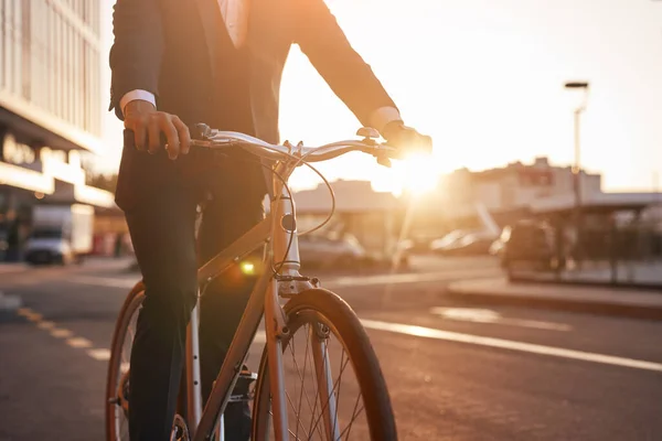 Crop entrepreneur riding bicycle in evening — Stock Photo, Image