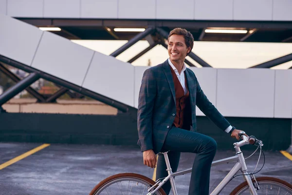 Hombre alegre moderno con bicicleta en el centro de negocios — Foto de Stock