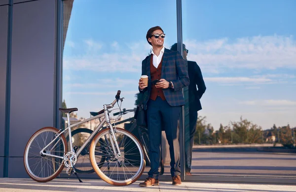 Веселый бизнесмен с велосипедом и кофе на вынос — стоковое фото