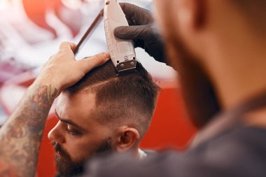 Kuaförde berber, hippi saçlarını buduyor.