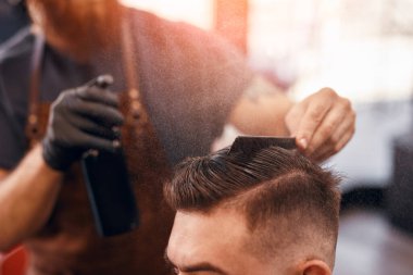 Modayı takip eden adamın yüzü olmayan berber tarzı saçı.