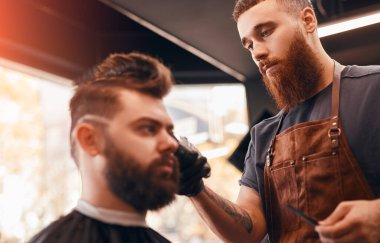 Havalı berber yakışıklı müşteriyi kuaförde tımar ediyor.