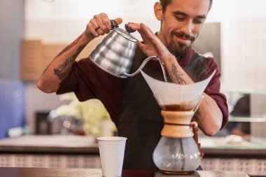 Kahveyi kağıt filtreyle demleyen Barista.