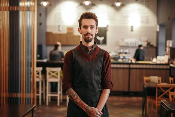 Amistoso barista de pie en acogedora cafetería — Foto de Stock