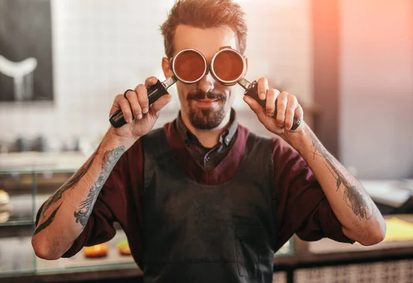 Hipster barista cubriendo los ojos con portafilters — Foto de Stock