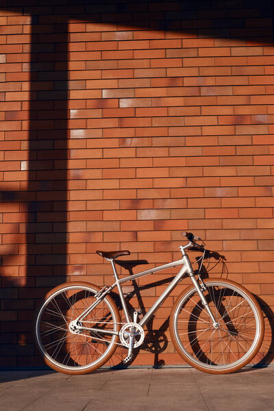 Велосипед припаркован возле кирпичной стены