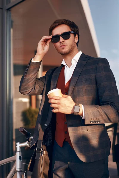 Hombre gerente con bebida para ir ajustando gafas de sol —  Fotos de Stock