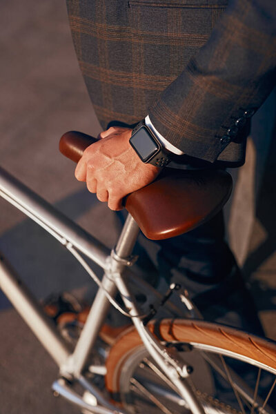 Elegant man with smart watch and bicycle