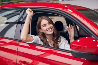 Yeni arabadaki mutlu kadın sürücü.