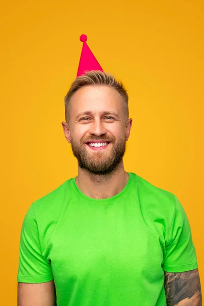 Śmiejący się facet w imprezowym kapeluszu gotowy do świętowania — Zdjęcie stockowe