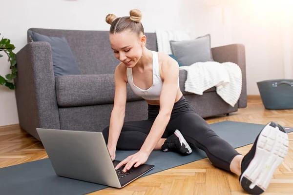 Trainer femminile che utilizza il computer portatile a casa — Foto Stock