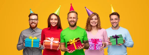 Fröhliche Freunde in Partyhüten mit Geburtstagsgeschenken — Stockfoto
